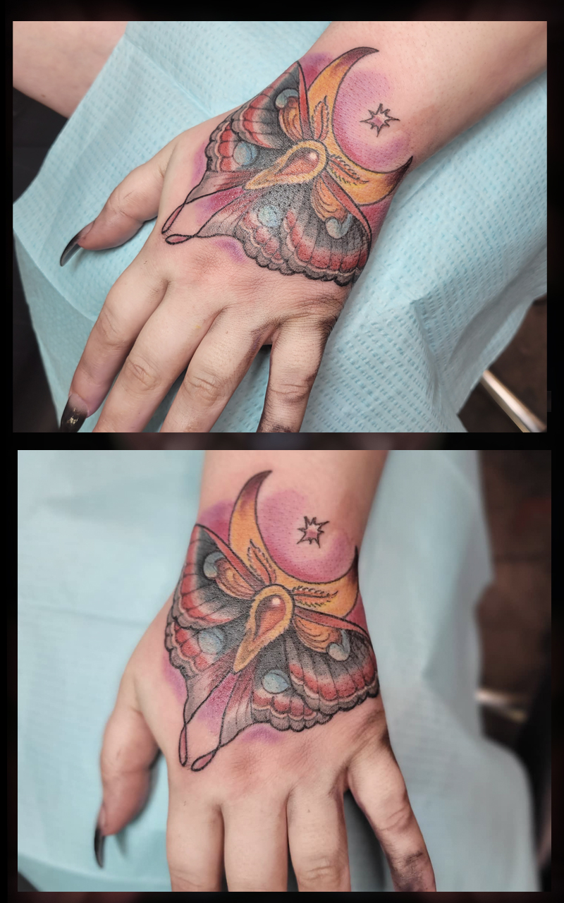 Colorful moth on hand tattoo