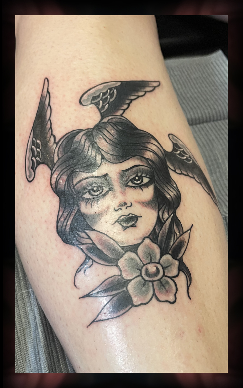 Woman with wings and flowers tattoo